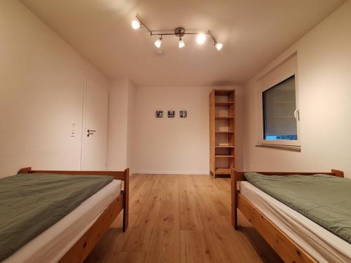 a bedroom with two beds and a window at Helle, großzügige Dachgeschosswohnung in Aichtal 