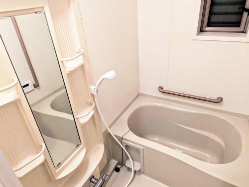 a bathroom with a bath tub and a mirror at Wood River House 門前仲町駅 木場駅 in Tokyo