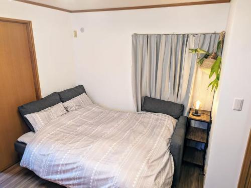 a small bedroom with a bed and a window at Wood River House 門前仲町駅 木場駅 in Tokyo