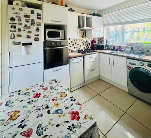 The Oasis Room - Fast Wi-Fi - Private Workspace في مانشستر: مطبخ بخزائن بيضاء وفرن موقد