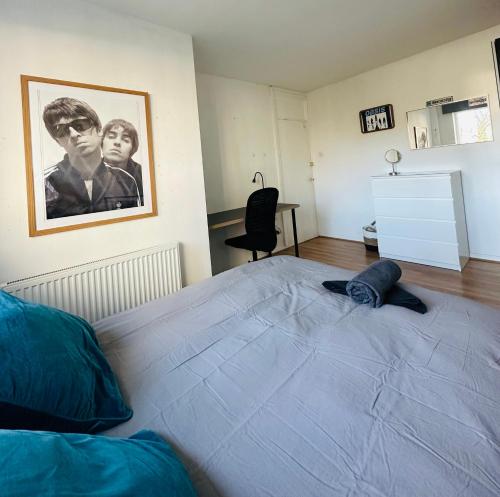 The Oasis Room - Fast Wi-Fi - Private Workspace في مانشستر: غرفة نوم بسرير كبير مع صورة على الحائط