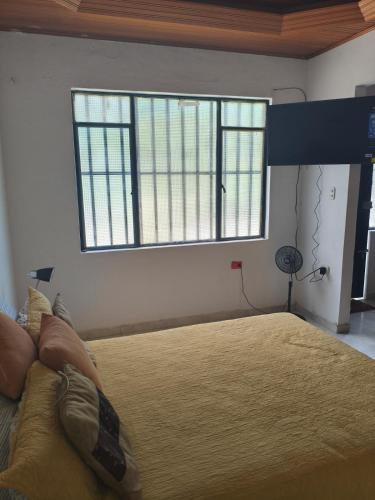 a bedroom with a large bed with two windows at beautiful and cozy studio apartment in San Martín