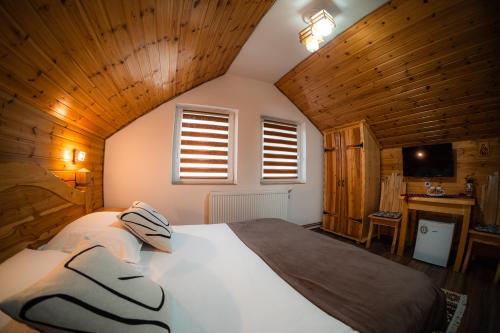 a bedroom with a large bed in a room with wooden walls at Pensiunea Casa Alexandra in Vatra Dornei