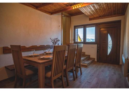 a dining room with a wooden table and chairs at Holiday home Maša - Kupres in Kupres