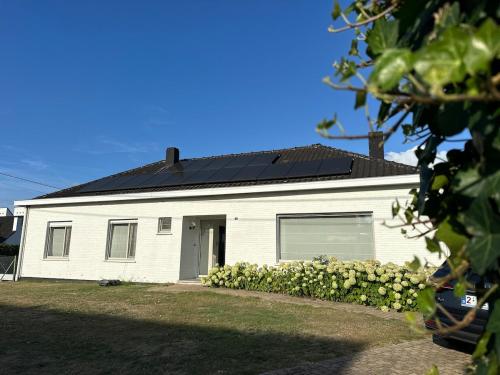 a white house with a black roof at Guesthouse Eekhoorn 16 in Kasterlee