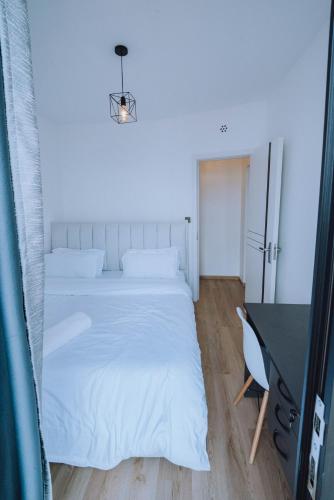 a bedroom with a white bed and a desk at Shan's Comfort Sanctuary in Tatu City