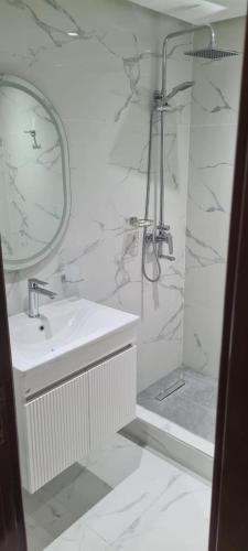 a bathroom with a sink and a mirror and a shower at Rabat in Temara