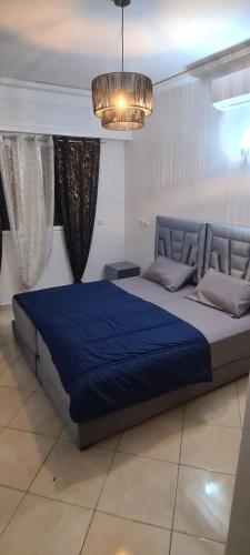 a bedroom with a large bed with a blue blanket at Rabat in Temara