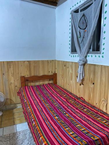een slaapkamer met een bed met een kleurrijke deken bij casa corazOm in Mar de Ajó