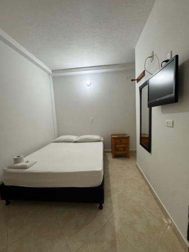a small bedroom with a bed and a mirror at Hotel Real Alejandria in Alejandría