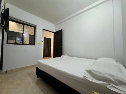 a bedroom with a large white bed with a window at Hotel Real Alejandria in Alejandría