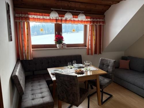 Pfeifferhof في ماريابفار: غرفة طعام مع طاولة وأريكة