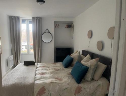 a bedroom with a large bed with blue pillows at Appartement paisible in Clichy