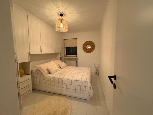 BEACH apartment met directe toegang tot het STRAND ! في كنوك هايست: غرفة نوم صغيرة بها سرير وضوء