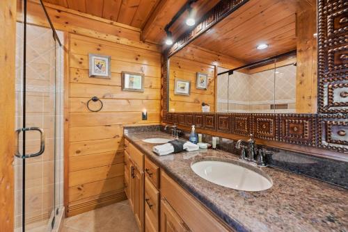 een badkamer met een wastafel en een spiegel bij Altitude Adjustment in Sevierville