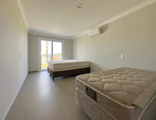 En eller flere senge i et værelse på Apê Aconchego - Capri Morada & Mar - Lateral Mar