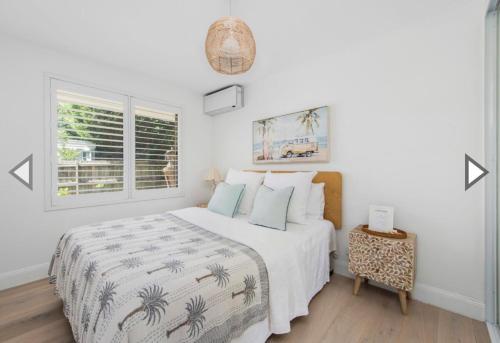 a white bedroom with a bed and a window at Freshwater Coastal Retreat 3BR Apartment in Freshwater