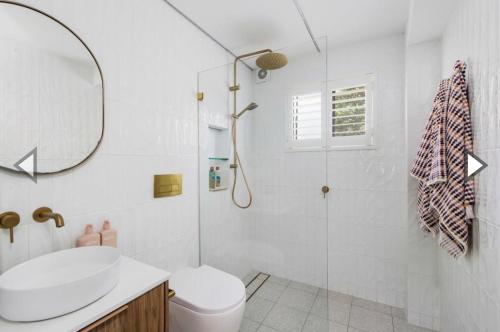 a bathroom with a toilet and a sink and a mirror at Freshwater Coastal Retreat 3BR Apartment in Freshwater
