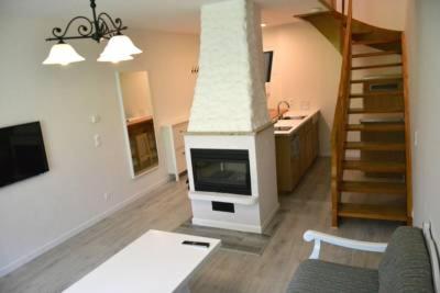 ein Wohnzimmer mit einem Kamin und einer Treppe in der Unterkunft Bad Ischl area Holiday Apartment in Bad Ischl