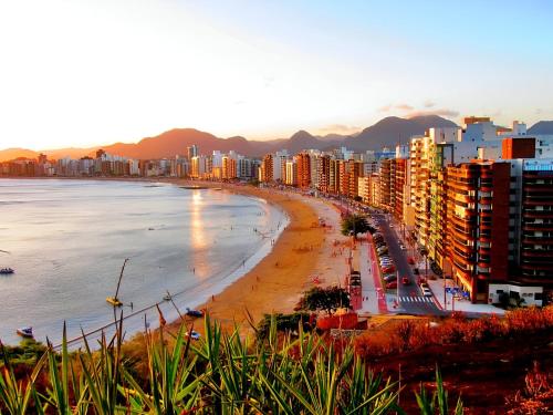a view of a beach with buildings and the ocean at Conforto Frente ao Mar - Areia Preta in Guarapari