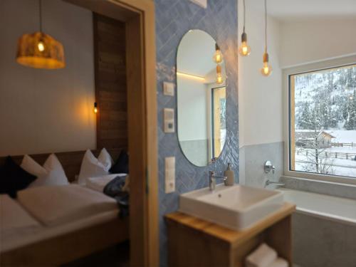 a bathroom with a sink and a couch and a mirror at Lake View Lodge in Flachau