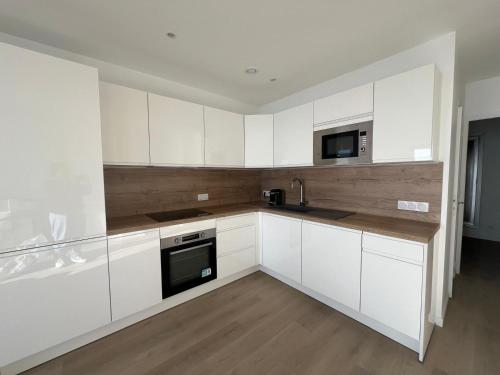 Una cocina con gabinetes blancos, un fregadero y un microondas. en Cap d'Ail - Sea view - 2 bedrooms 3 beds - Rotterdam, en Cap d'Ail