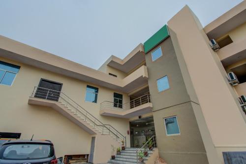 斋浦尔Hotel O Dream Palace的停在建筑物前的汽车