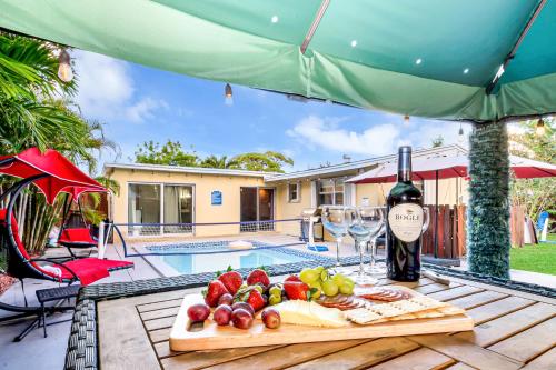 a table with a plate of food and a bottle of wine at Relax at Serenity Heated Pool Spa BBQ Near Beach in Palm Beach Gardens