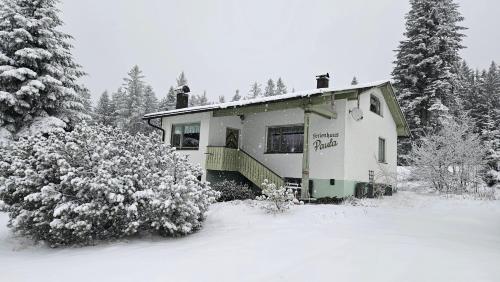 a house is covered in snow with trees and trees at Arber Haus Paula in Bayerisch Eisenstein
