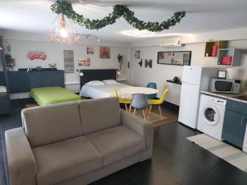 ein Wohnzimmer mit einer Couch, einem Bett und einem Tisch in der Unterkunft Budha GuestHouse in Porto