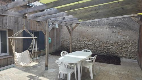 a patio with a white table and white chairs at Le Petit Caporal - Cour Privée - Parking Privée in Bracieux