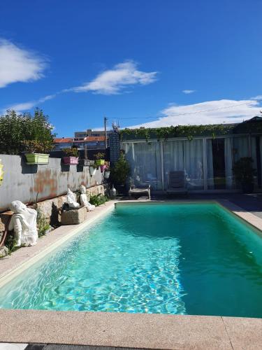 a swimming pool with blue water in a yard at Budha GuestHouse in Porto