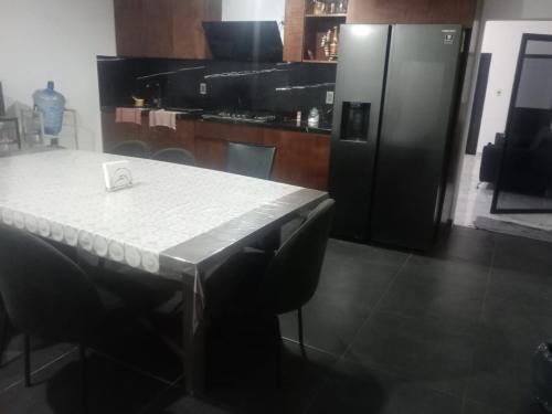 a kitchen with a table and a black refrigerator at casa ex hacienda casasano in Cuautla Morelos