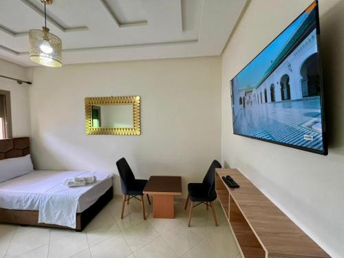 フェズにあるResidence Noor - Central Apartments Fesのベッドとテーブルとテレビのある寝室