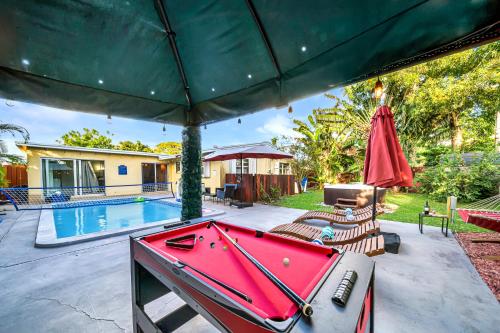 a pool table on a patio next to a swimming pool at Relax at Serenity Heated Pool Spa BBQ Near Beach in Palm Beach Gardens