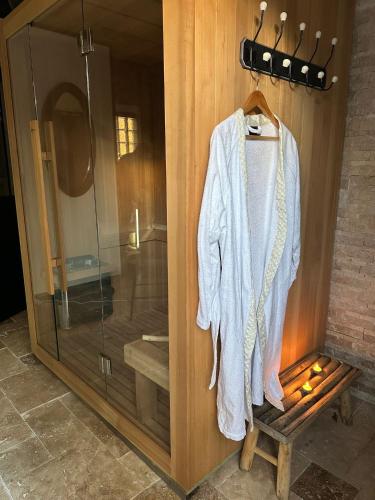 a robe hanging on a wooden wall next to a shower at Appartement de luxe "L'Écrin de l'Amour" in Saint-Avertin