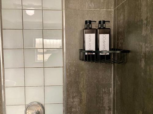 Unit 2 TraversHub Sleeps 6 Self-Catering Group Belhar, CT في Belhar: زجاجتان من الروائح تقعان على رف في الحمام