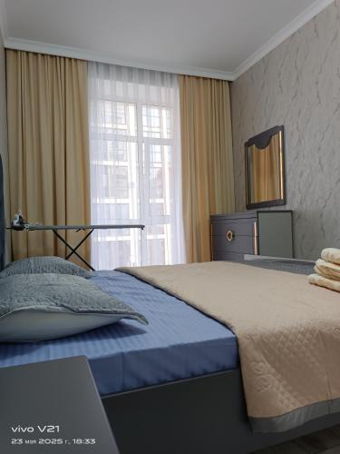 Un dormitorio con una cama grande y una ventana. en Мадрид, en Astana