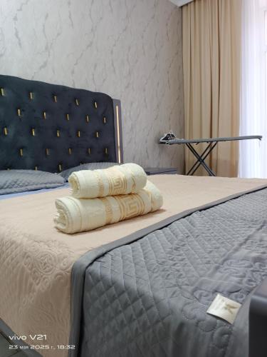 una cama con dos almohadas encima en Мадрид, en Astana