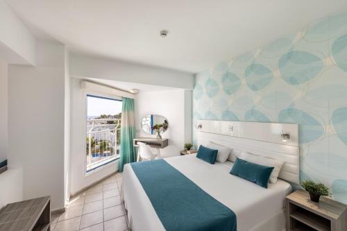 a bedroom with a large bed and a window at Lantiana Gardens ApartHotel in Protaras
