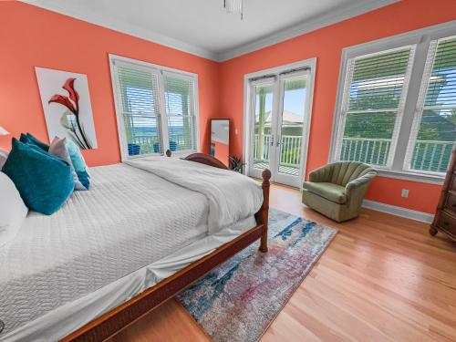 a bedroom with orange walls and a bed and a chair at Surfer Dog l Beachfront Pool l Includes Beach Chairs and Bikes in Inlet Beach