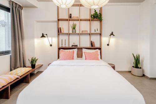 Dogpound Hotel في أثينا: غرفة نوم مع سرير كبير مع وسائد وردية