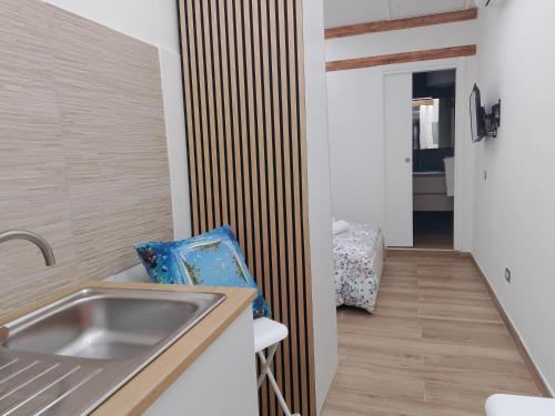 een keuken met een spoelbak en een houten scheidingswand bij B&b Carlotta in Pozzuoli