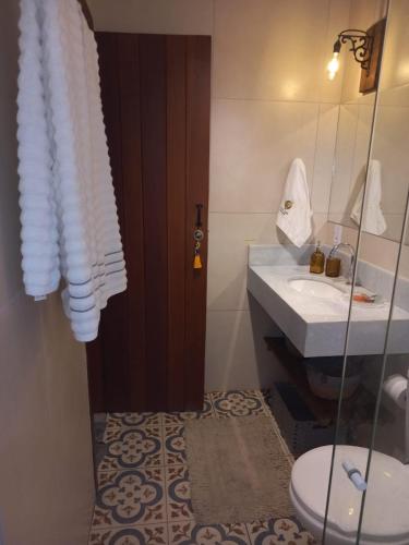 a bathroom with a toilet and a sink at Chalé Colibri in Vale do Capao