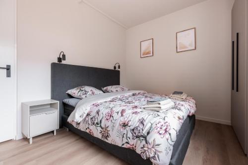 a bedroom with a bed with a floral bedspread at Luxe appartement op toplocatie in centrum Rotterdam Stay&Rejoice in Rotterdam