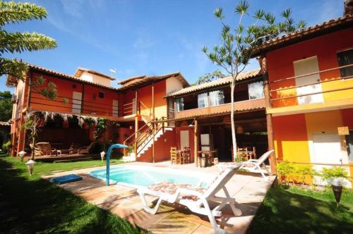 a house with a swimming pool in front of it at Mandacaru Pousada in Porto Seguro