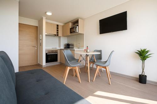 Una sala de estar con mesa y sillas y una cocina. en la cuidad en las alturas, en Concepción