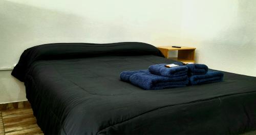 Departamento en El Calafate para dos personas في إل كالافاتي: سرير عليه بطانيات زرقاء