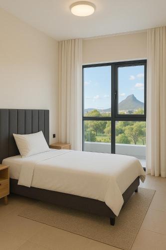 a bedroom with a large bed and a large window at Splendid Mountains View Three Bedroom Apartment in Moka