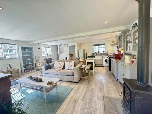 ein Wohnzimmer mit Sofa und Tisch in der Unterkunft Charming Dog-Friendly Guesthouse in Sidbury